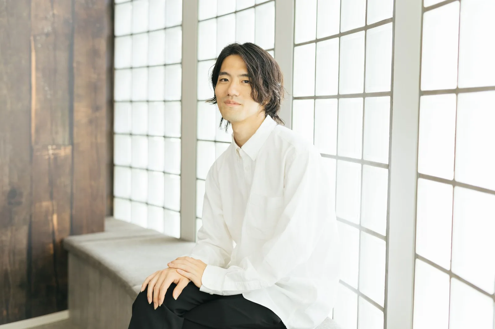 窓辺に座って話す若林純さん